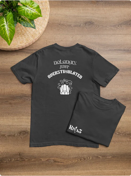 Black t-shirt with white text and graphics on a wooden surface