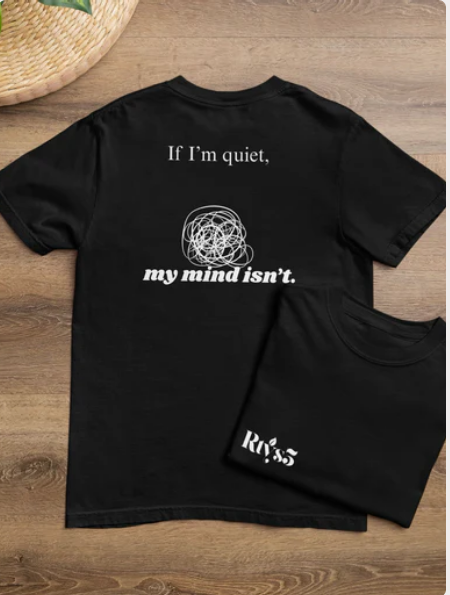 Black t-shirt with white text and design on a wooden surface